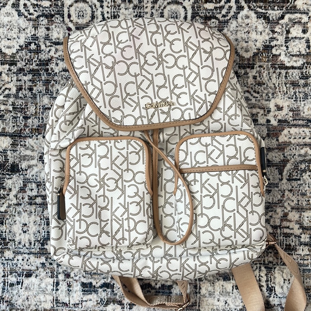 Calvin Klein backpack purse. Colors are white and tan with CK letter print.